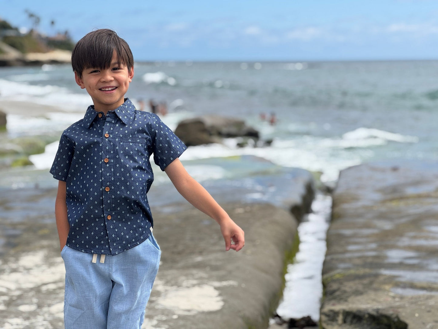 Child standing on a beach with ocean in the background