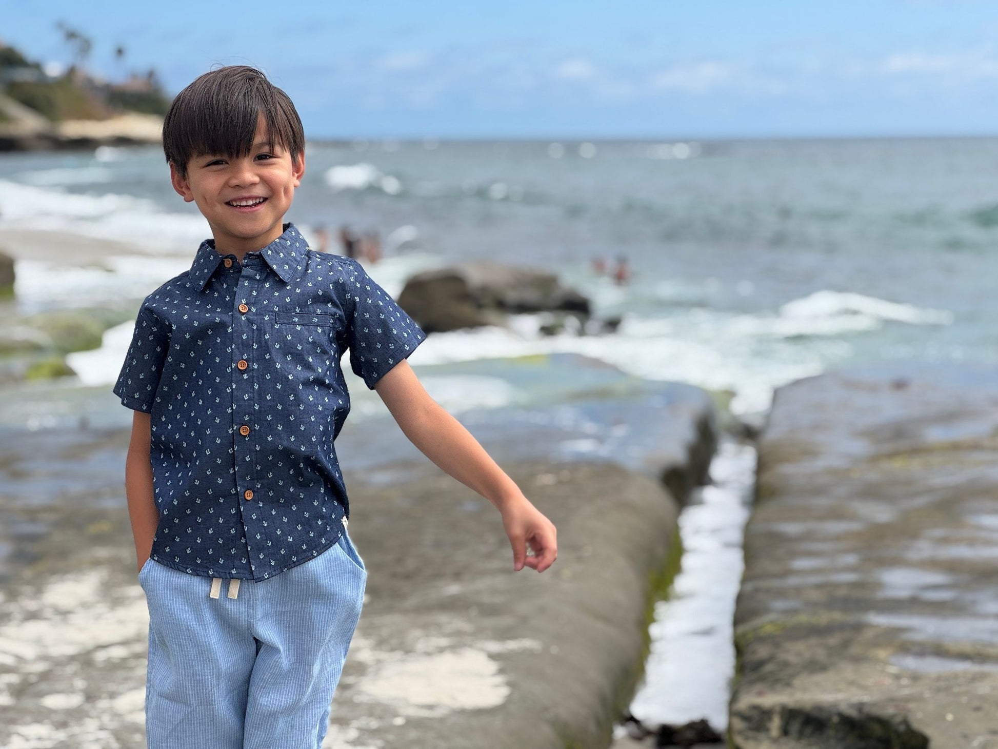 Child standing on a beach with ocean in the background