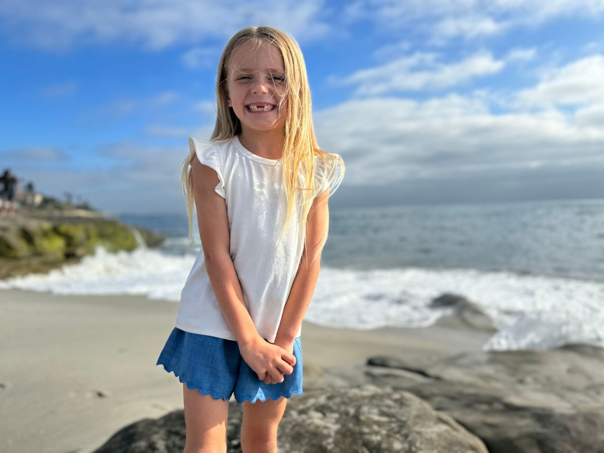 Young girl standing on a beach with ocean waves in the background