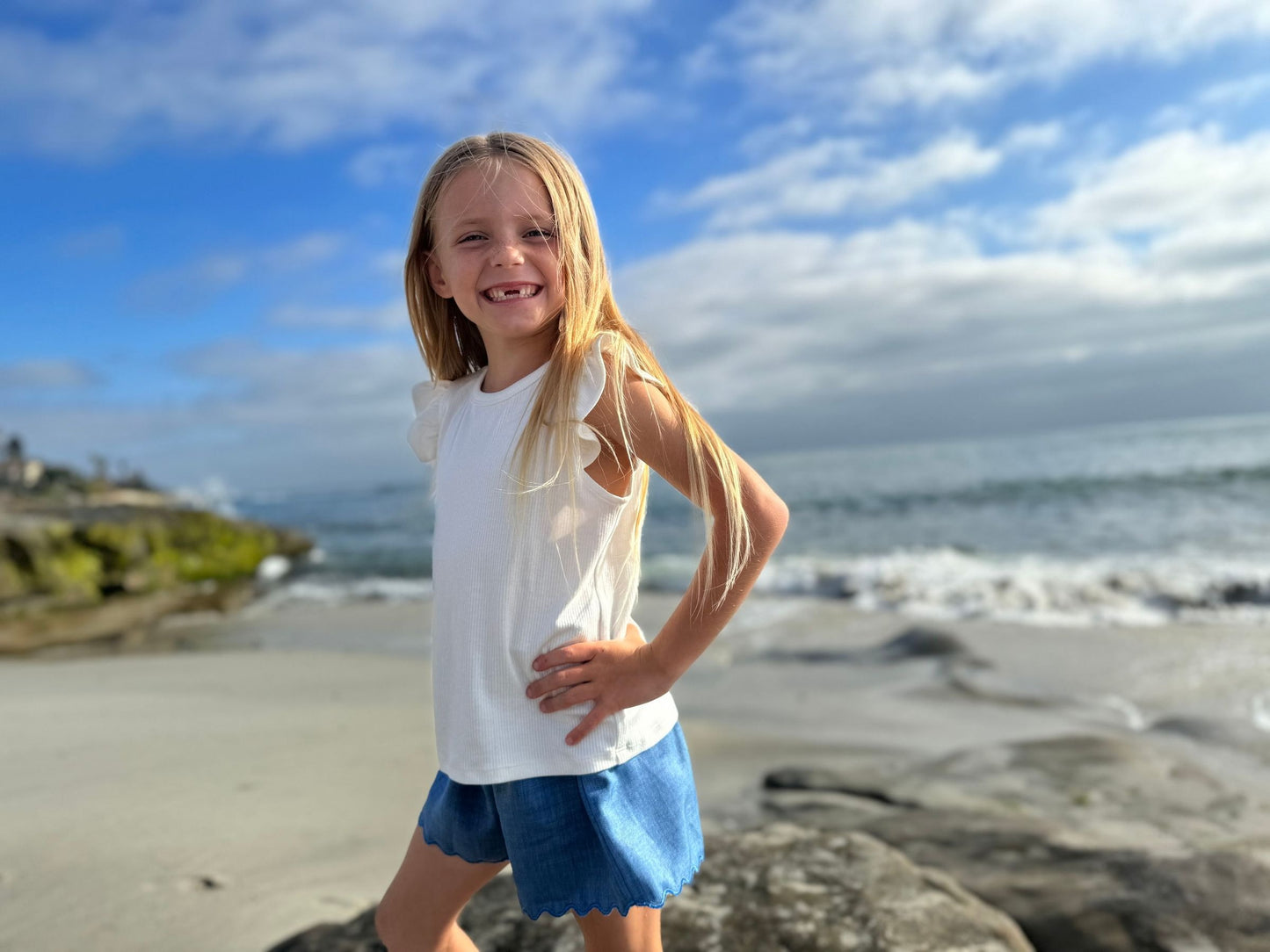 Young girl on a beach with ocean and sky in the background
